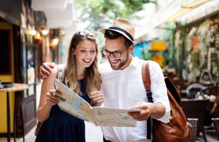 Happy young couple looking at a map during their travel